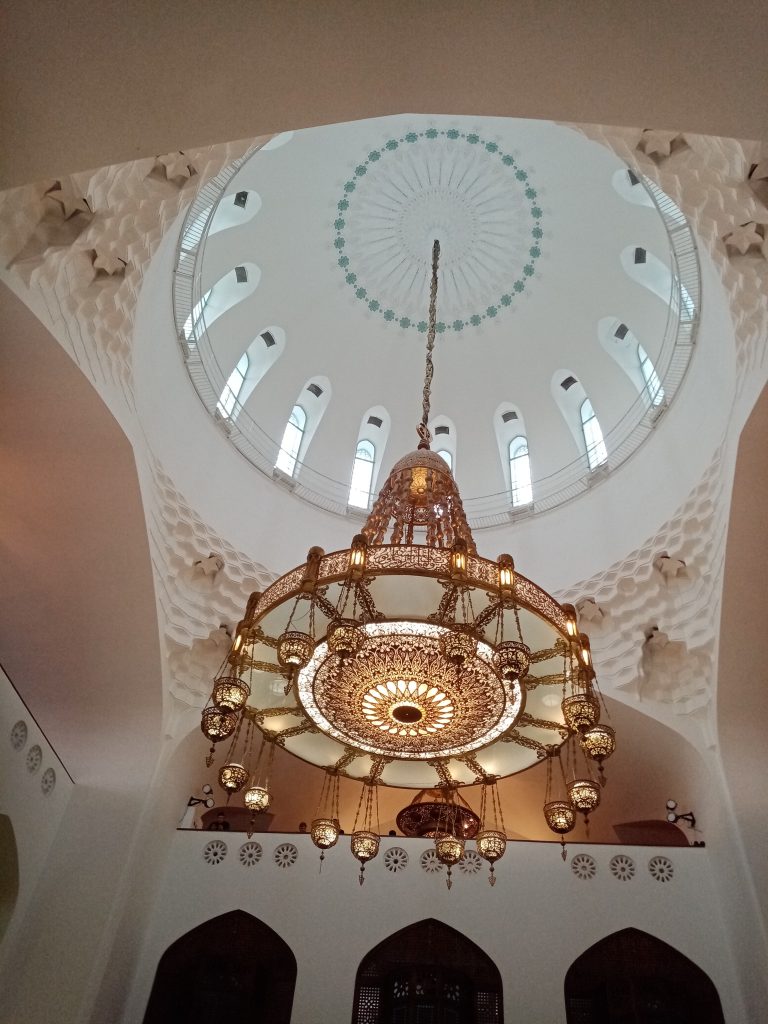 Мусульманская мечеть в Санкт-Петербурге Мусульманская мечеть в Санкт-Петербурге — величественное здание с синим куполом и двумя стройными минаретами, выполненное в традиционном восточном стиле. Фасад украшен глазурованной керамикой, геометрическими узорами и арабской вязью. На переднем плане — тихая городская улица с зеленью, подчёркивающая духовную атмосферу и культурное многообразие Петербурга